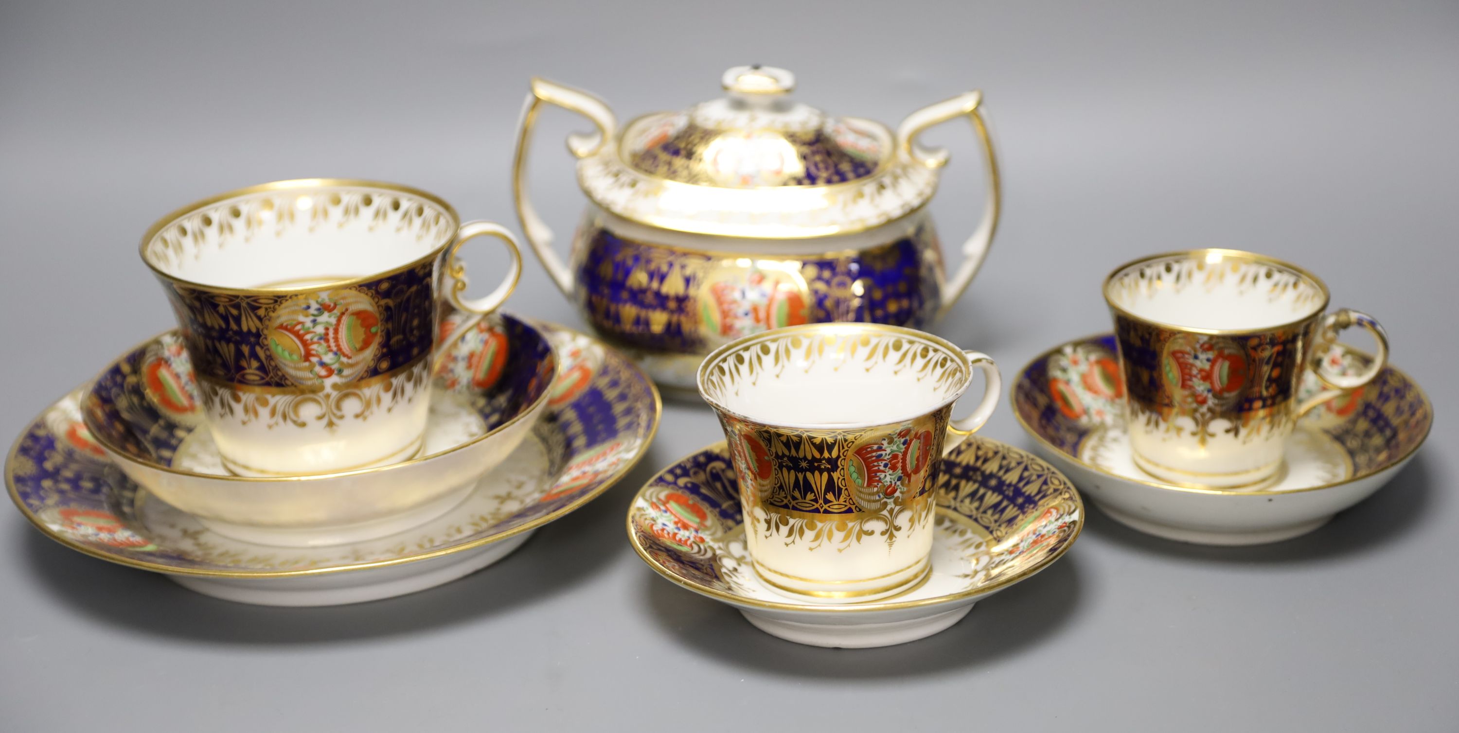 An early 19th century Chamberlains Worcester imari-style graduated set of three cups and saucers, a plate and a sucrier and